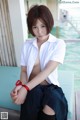 A woman in a white shirt and black skirt sitting on a bench.