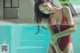 A woman in a red bathing suit standing in a pool.