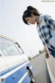 A woman standing next to a blue and white van.