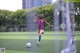 A young girl kicking a soccer ball on a field.