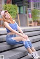 A woman sitting on the steps of a building wearing a pink hat.