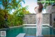 A woman in a white dress standing in a pool.