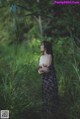 A woman standing in a field of tall grass.