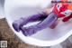 A person in a bathtub with a pair of purple boots.