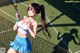 A woman holding a tennis racquet on a tennis court.