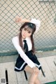 A woman in a school uniform sitting on a bench.