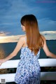 A woman in a blue and white dress standing on a balcony.