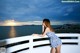 A woman in a blue and white dress standing on a balcony.