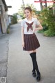 A woman in a school uniform is posing for a picture.