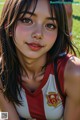 A woman in a red and white shirt sitting on a field.