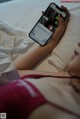 A woman laying in bed holding a cell phone.