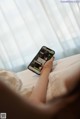 A person laying in bed holding a cell phone.