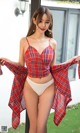 a woman in a red plaid shirt and white panties posing for the camera