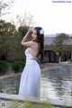 A woman in a white dress standing in a pool.